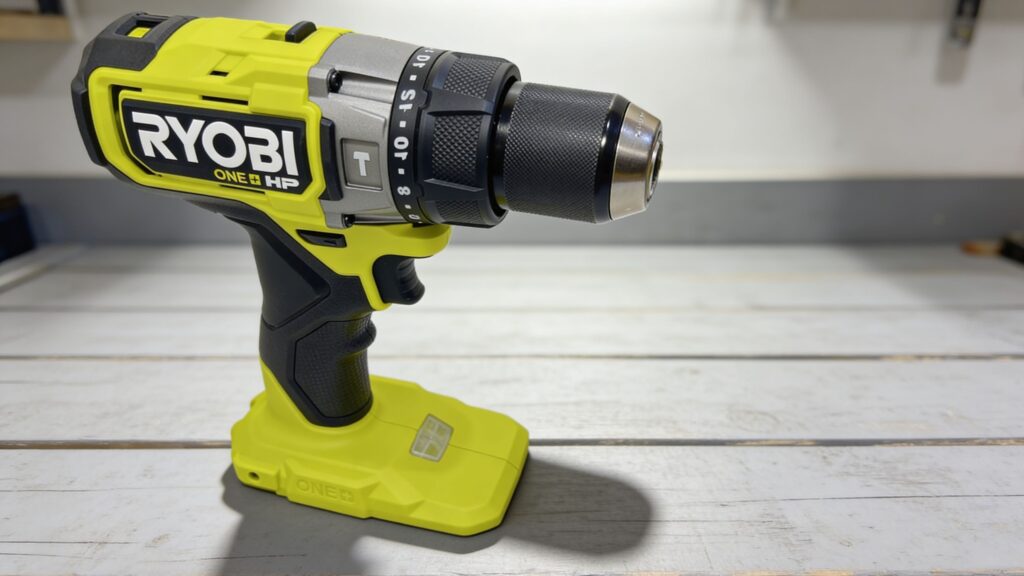 Close-up view of a hammer drill in action driving into a concrete wall, showing dust particles, rotating bit motion, and internal percussion force demonstration in a workshop setting